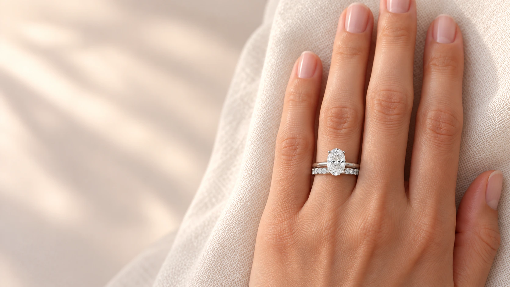 engagement ring and wedding band stacked on the ring finger of a left hand
