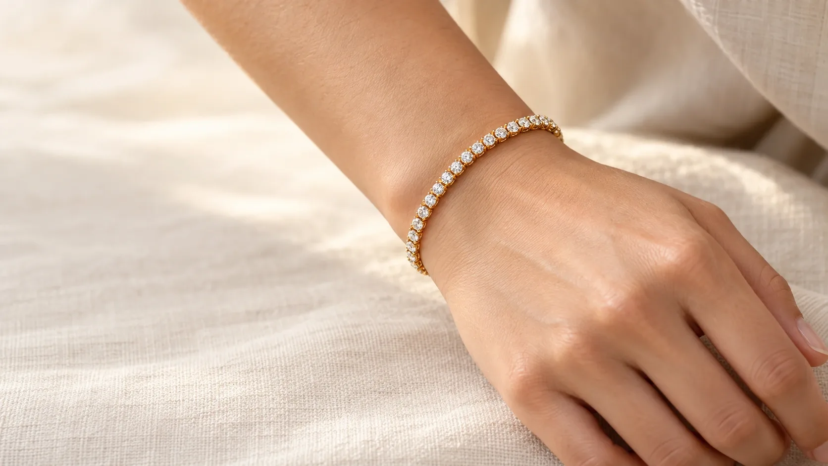 yellow gold diamond tennis bracelet with one line of round diamonds on a relaxed wrist