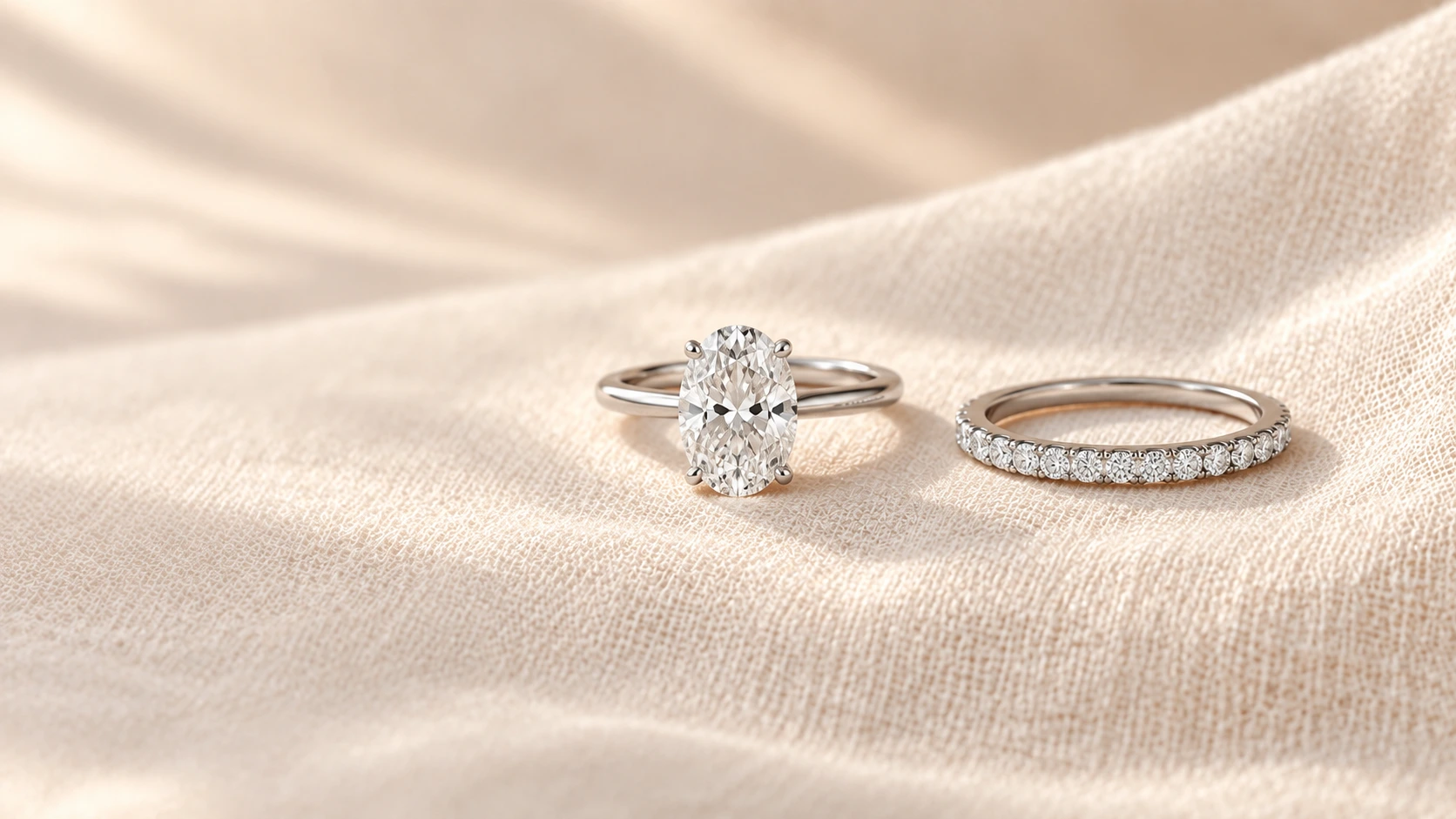 an engagement ring with an oval diamond next to a slim diamond wedding band